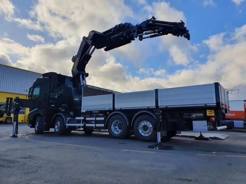 Camion bras de grue Palfinger PK135.002TEC en levage sur chantier en Île-de-France