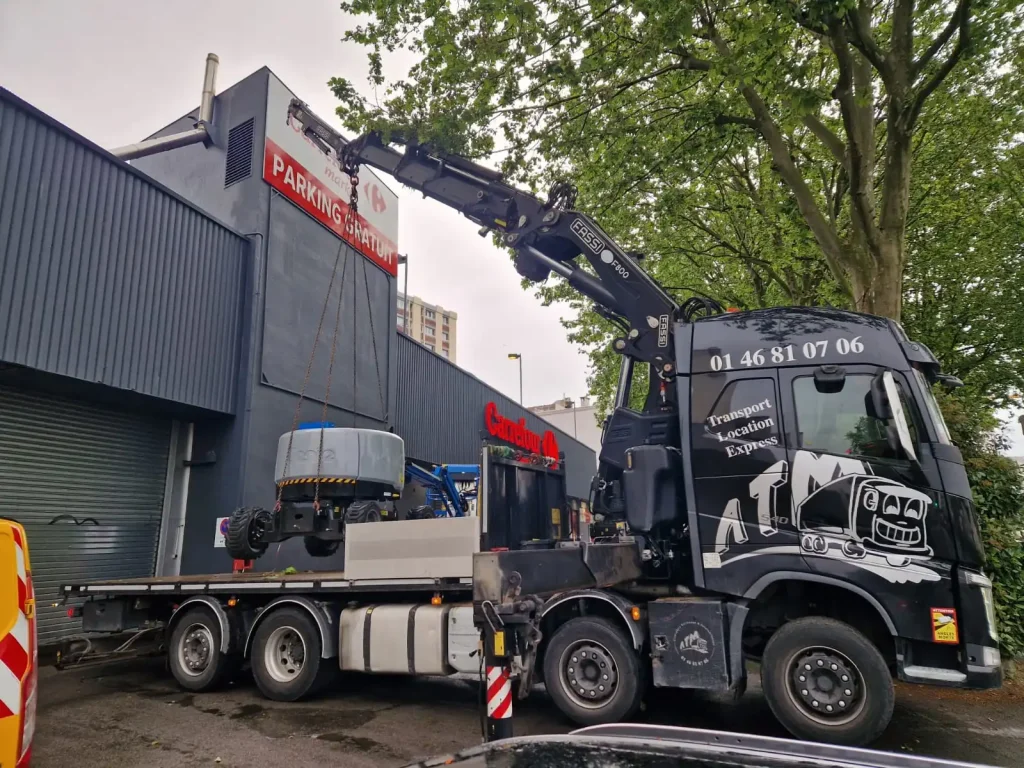 Camion bras de grue Fassi F800RA.2.28 en levage sur chantier en Île-de-France