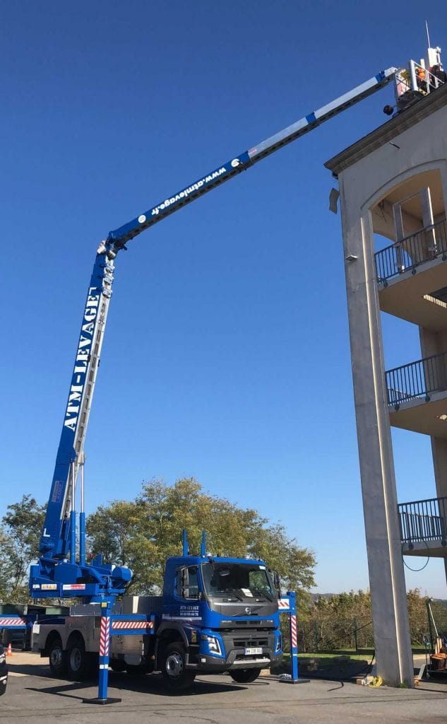 Grue aluminium KLAAS K1003 en levage sur chantier urbain